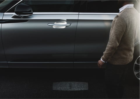 A person approaches a 2023 Lincoln Aviator® Grand Touring as the Lincoln Embrace sequence of welcome lighting illuminates | Oliver Lincoln in Plymouth IN