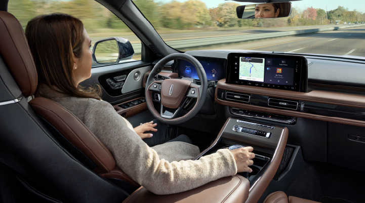 A woman is seen sitting in the driver’s seat of her 2025 Lincoln Aviator® SUV with her hands off the steering wheel. | Oliver Lincoln in Plymouth IN