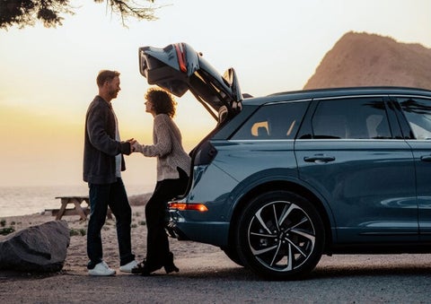 A couple share a moment together outside a 2025 Lincoln Corsair® SUV near the open liftgate. | Oliver Lincoln in Plymouth IN