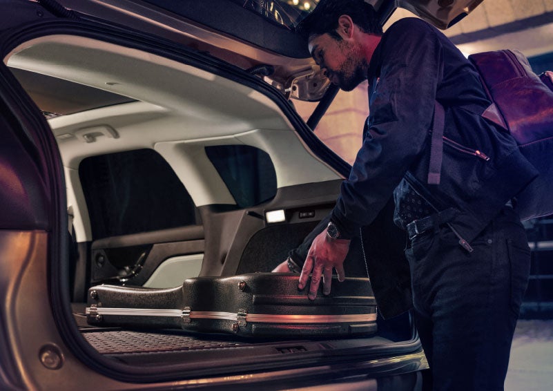 A man is shown loading cargo into the rear of a 2024 Lincoln Corsair® SUV with the second-row seats folded flat. | Oliver Lincoln in Plymouth IN