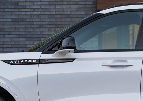 The driver’s side door and fender badging of a white 2026 Lincoln Aviator® SUV are showcased. | Oliver Lincoln in Plymouth IN