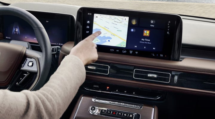 A person is tapping the center display touchscreen of a 2026 Lincoln Aviator® SUV. | Oliver Lincoln in Plymouth IN