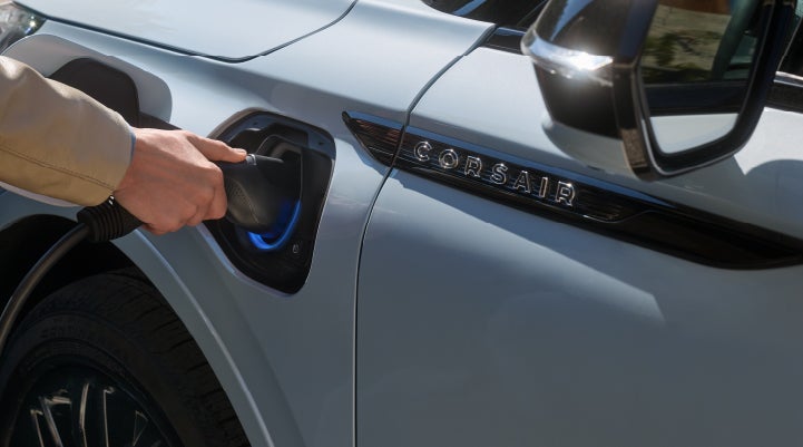 A hand is plugging in a 2026 Lincoln Corsair® Grand Touring Plug-in Hybrid SUV. | Oliver Lincoln in Plymouth IN