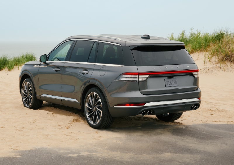 A 2027 Lincoln Aviator® SUV is parked next to sand dunes. | Oliver Lincoln in Plymouth IN