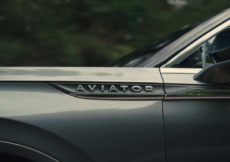 The driver’s side door and fender badging of a gray 2027 Lincoln Aviator® SUV are showcased. | Oliver Lincoln in Plymouth IN