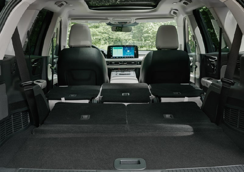 A rear to front view of the interior of a 2027 Lincoln Aviator® Black Label™ SUV shows the third and second rows folded flat | Oliver Lincoln in Plymouth IN